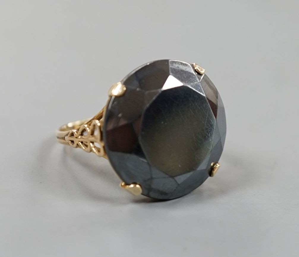 A yellow metal and facet cut hematite dress ring, size Q/R, gross weight 7.1 grams.